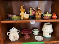 Wide view of two-shelf lot showing all ceramic pieces