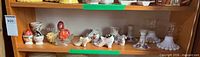 Shelf view showing egg cups, decorative eggs, shoe figurines, candlesticks, chimneys