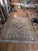 Full view of the handmade geometric rug on hardwood floor