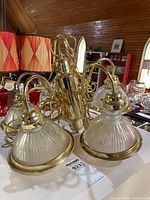 Overall view of chandelier showing five glass shades and brass body