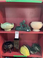Shelf with eight ceramic pieces showing overall lot