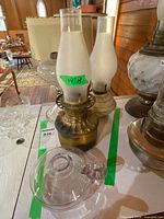 Group shot showing brass lantern, clear glass lamp, ceramic-base lamp