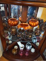 Front view showing all candle holders and bowls in display cabinet