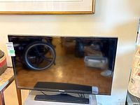 Front view of Samsung UN32EH4003F TV on stand