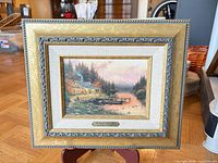Front view of framed Thomas Kinkade print showing artwork, frame, mat and title plaque