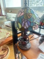 Full view of stained glass table lamp on shelf