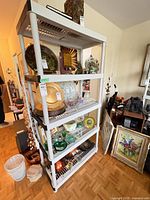 Full view of white plastic five-tier shelving unit with items displayed (items not included)