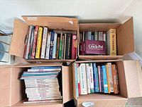 Three boxes filled with a variety of books and magazines
