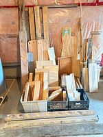 Full view of assorted wood pieces in crates and leaned against wall