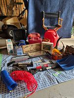 Overview of lot showing chair, jerry cans, boxed items, polisher, hoses, shovel