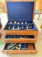 Chest open showing top compartment with knives and serving pieces