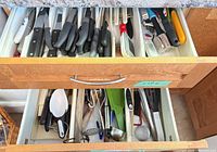 Two drawers with assorted knives and utensils