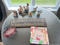 Overall lot view with sign, figurines, plaque and canvases