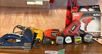 Group shot showing Skil drill with box, Dewalt screw gun, stapler, AutoTape, tape measures
