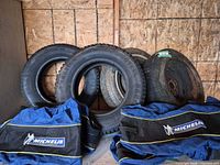 All four tires standing with two Michelin bags visible