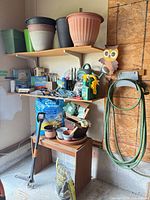 Overall shelving with pots, watering can, chemicals, hose, hand tools, soil bag