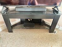 Front view of entire TV stand with glass top and lower shelf