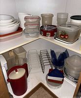 Overall cabinet view showing bowls, pitchers, containers, racks
