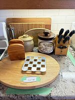 Full lot showing cutting boards, knife block, canisters, trivet, pepper mill, wooden holders