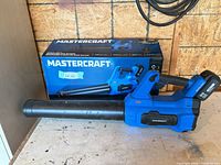 Leaf blower with tube attached, battery installed, box visible