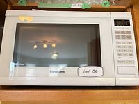 Front view of Panasonic white microwave showing door and branding