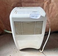 Front view of Whirlpool dehumidifier with grille, hose, power cord