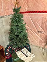 Full view of assembled pre-lit tree with star topper, tree skirt and stockings