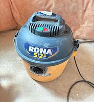 Top and side view of RONA wet/dry vacuum showing brand label and canister