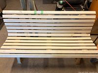 Full frontal view of slatted bench showing overall design and condition