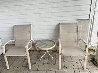 Full view of two sling chairs and table on patio