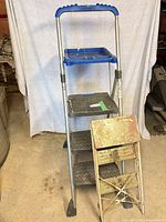 Tall aluminum 3-step ladder and shorter metal 2-step stool overall view