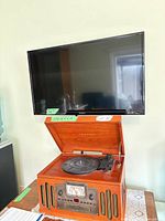 Crosley CR704 on table below wall-mounted 32" Westinghouse TV