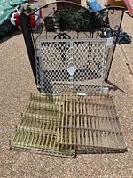All items grouped: fireplace screen, baby gate, stack of wire racks