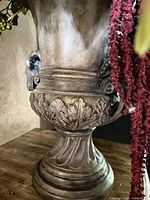 Close-up of urn base showing resin material, aged bronze finish and acanthus detailing