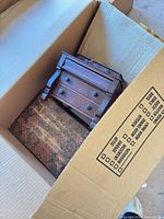 Overview showing miniature dresser-style chest and marbled-paper box inside shipping carton