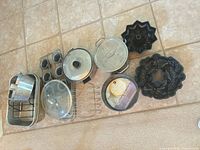 All cookware and bakeware pieces laid out on floor