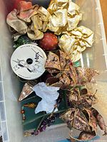 Overview of bin containing bows, ornaments, ribbon spool, garland