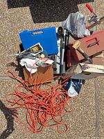 Overall view showing extension cord, toolboxes, mallet, blue case, hand truck