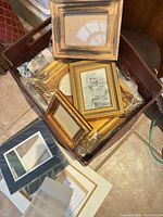 Basket containing several gold frames, one rustic wood frame on top, mats visible