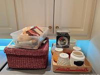Overall lot showing woven basket, plastic tub, scale, glass jars, ceramic canister