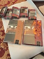 Seven sealed packages showing two tablecloths and five seat cover sets