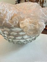 Side view of clear pressed glass basket showing diamond pattern texture