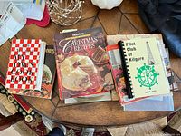 Stack showing My Own Cook Book, Paula Deen title, Southern Living Christmas Recipes, Pilot Club of Kilgore binder and others