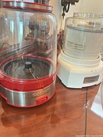Red and stainless base with clear plastic popping chamber beside white control base