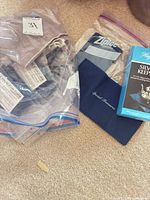 Assorted cloths in clear bag, Ziploc bag, Special Treasures cloth, Hagerty Silver Keeper box visible