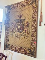 Full view of tapestry hanging on wall with rod and tassels visible