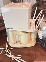 Waterpik countertop water flosser with tips and cord visible