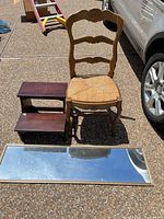 Chair, step stool, and mirror grouped together outdoors