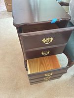 Nightstand perspective with two drawers open showing brass pulls and veneer finish