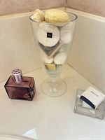 Lot overview showing Mikasa vase filled with soaps, purple perfume bottle, Elemis boxed soap